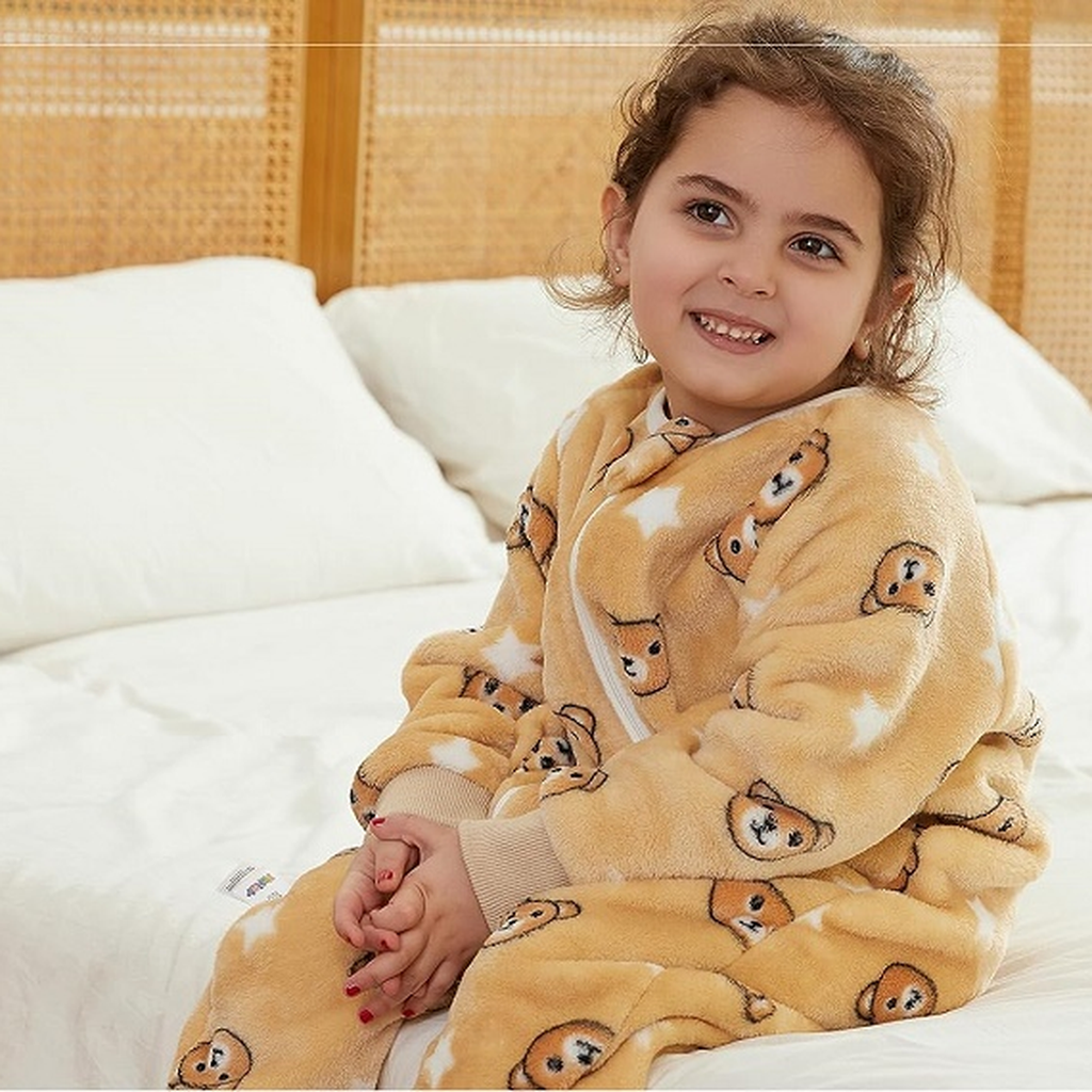 Fille souriante blottie dans sa combinaison pyjama beige à oursons