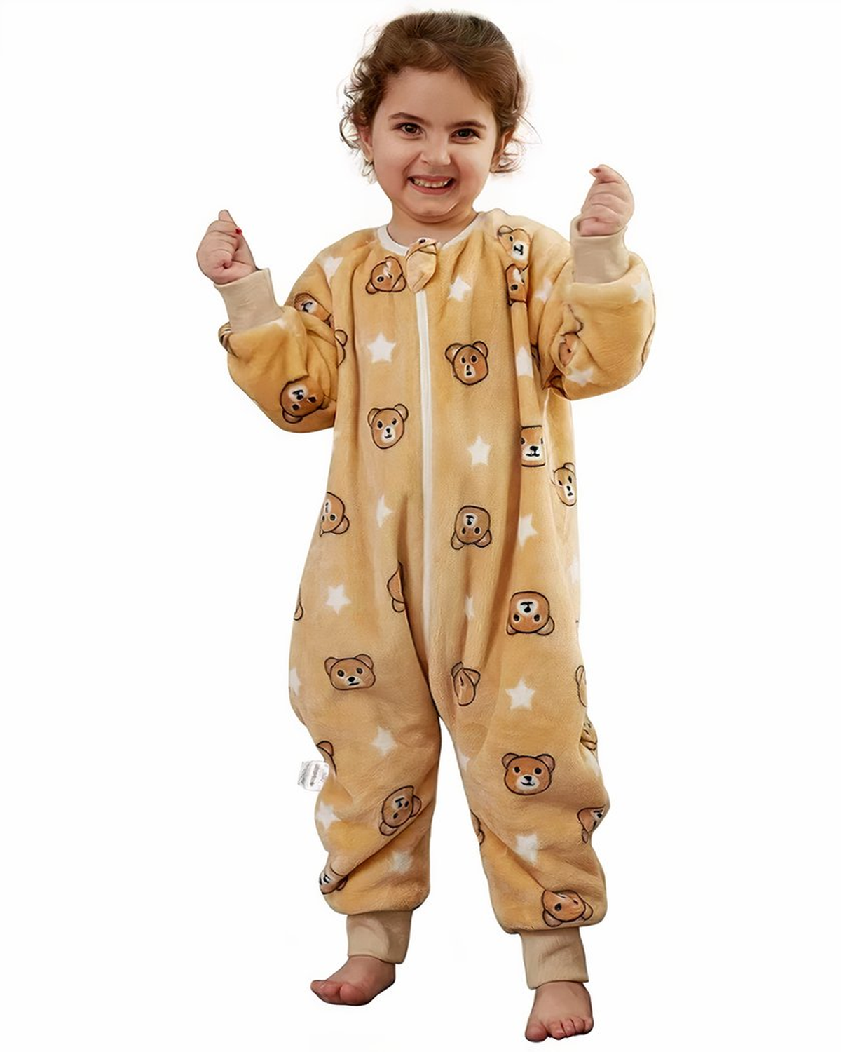 Fille souriante portant la combinaison pyjama beige à oursons et étoiles
