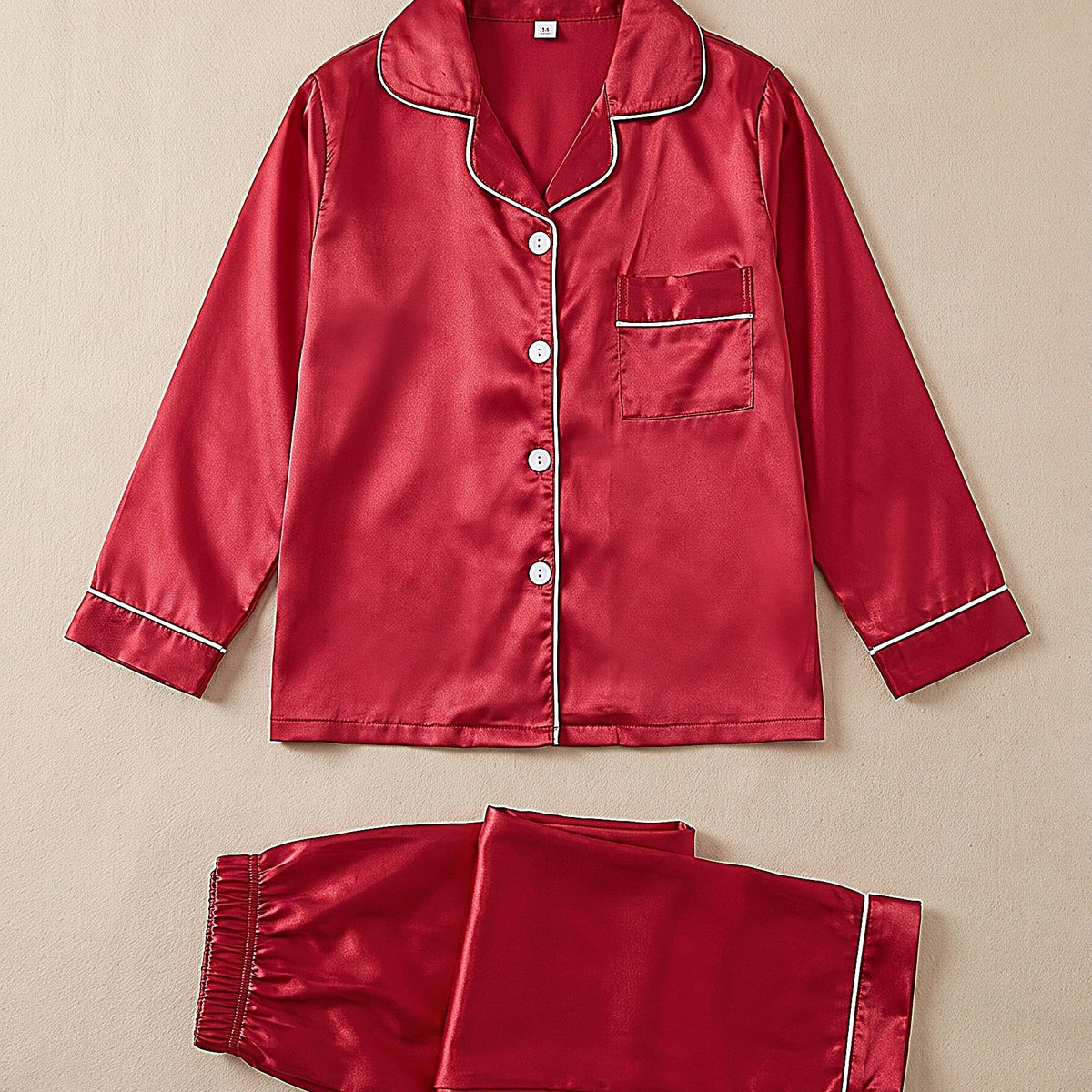 Ensemble pyjama fille en satin rouge présenté à plat, chemise boutonnée et pantalon assorti