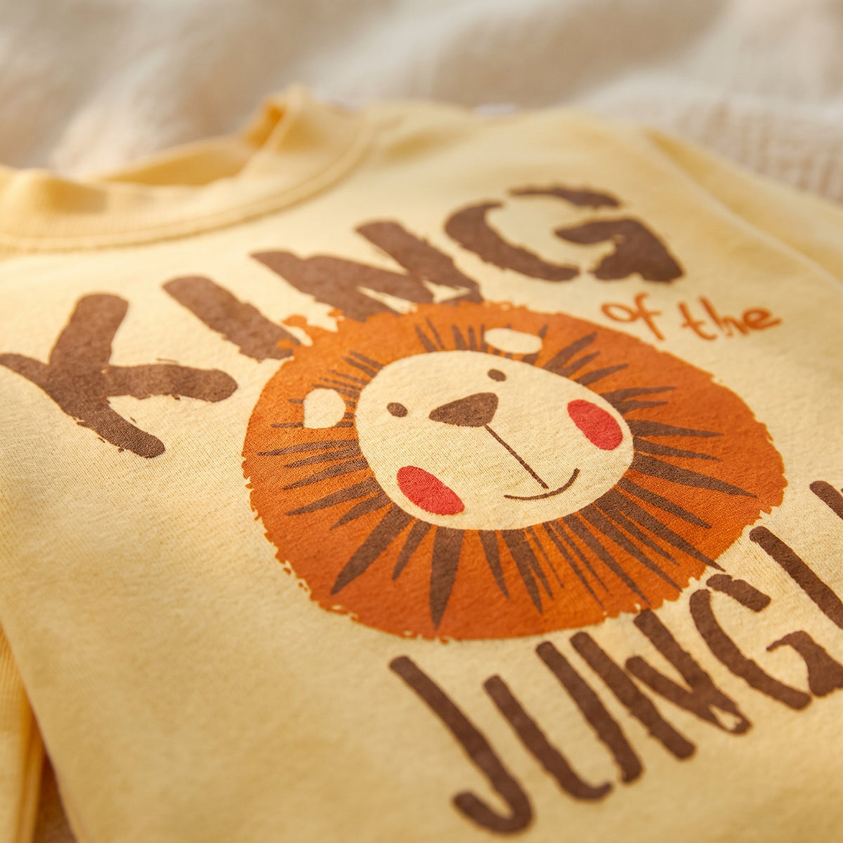 Gros plan sur le grand lion et les lettres imprimés sur le haut du pyjama garçon
