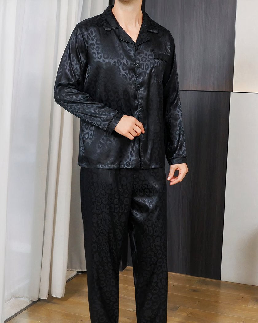 Pyjama homme en satin noir à motif léopard porté debout, boutonnage devant