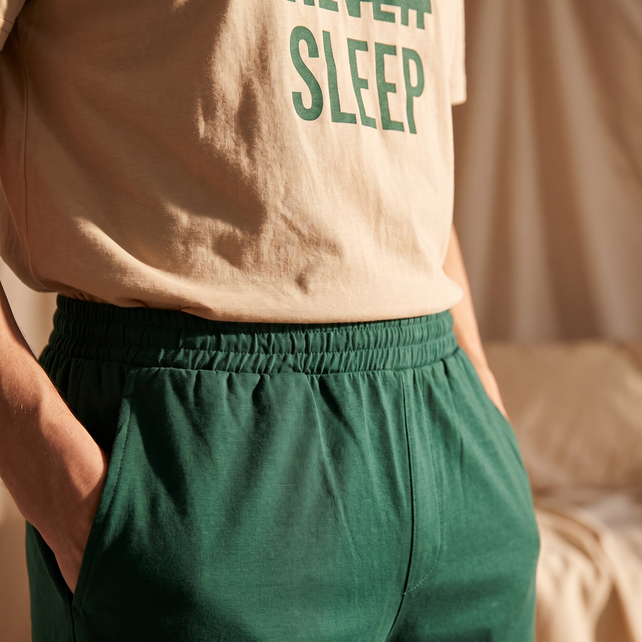 Gros plan sur la taille élastiquée du short vert et le t-shirt beige Never Sleep Image