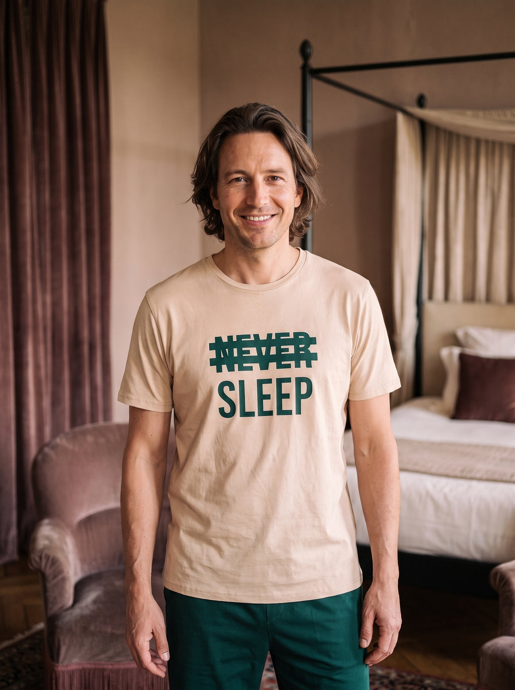 Homme souriant portant le pyjama beige et vert à inscription Never Sleep