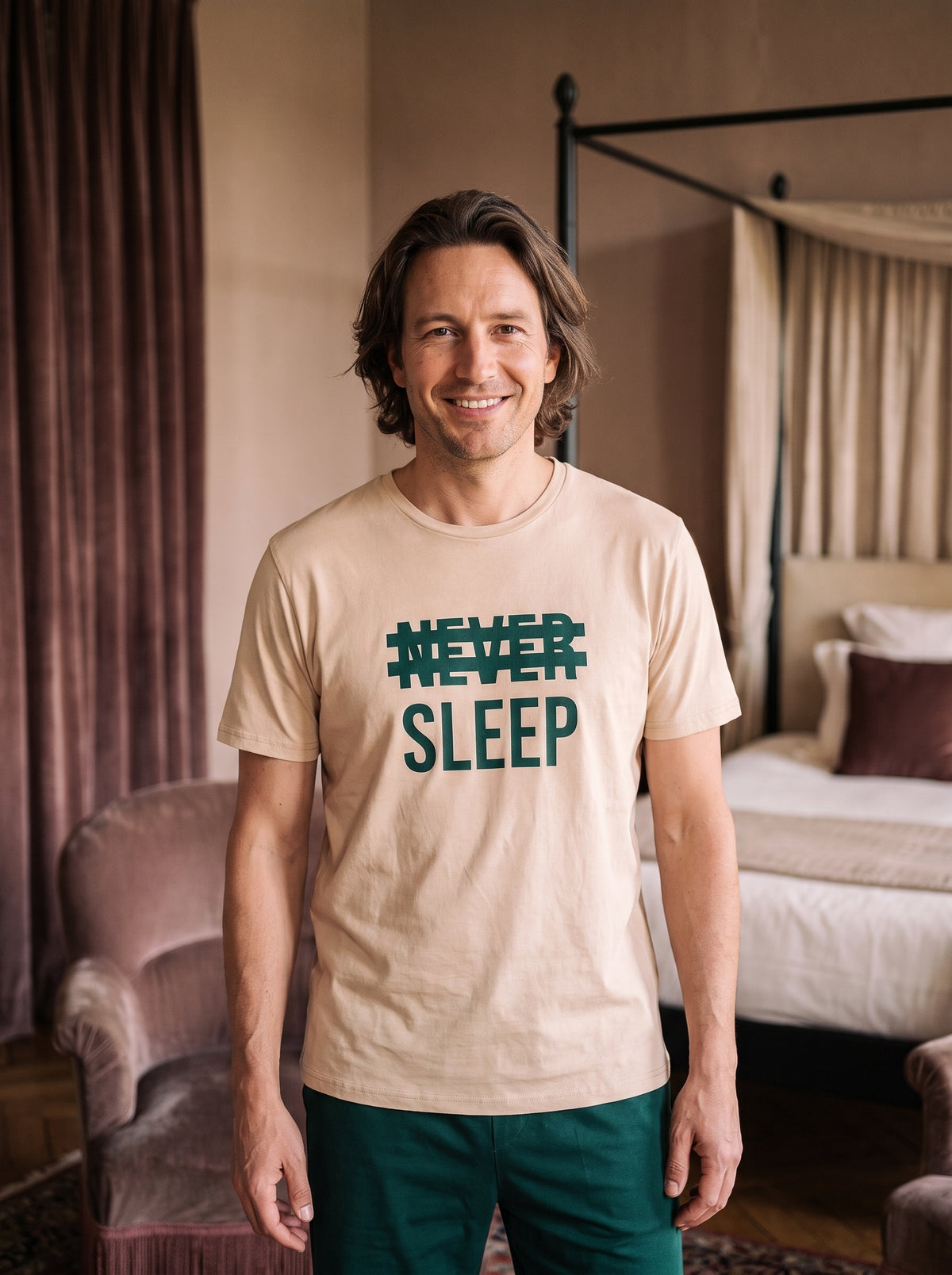 Homme souriant portant le pyjama beige et vert à inscription Never Sleep