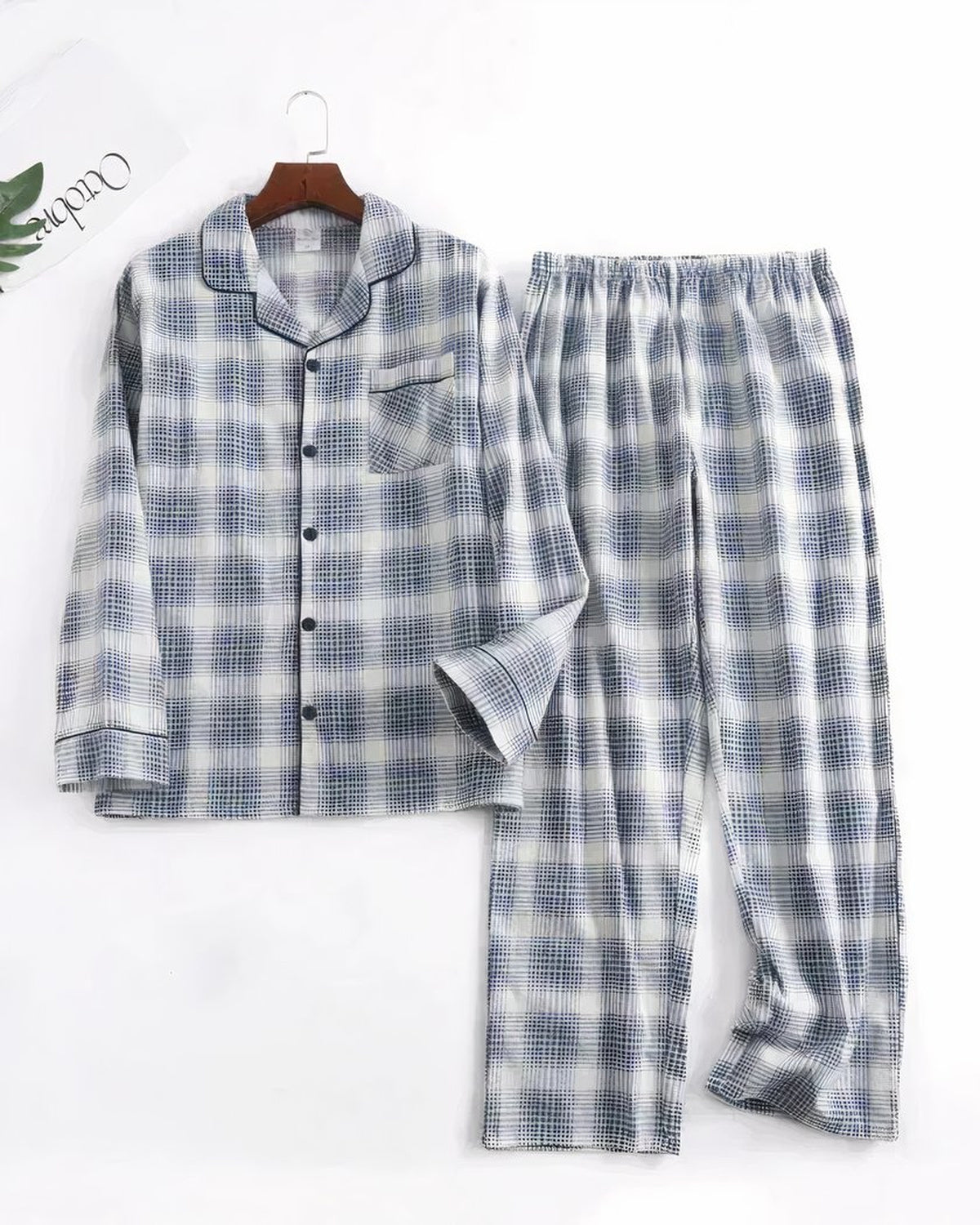 Ensemble de pyjama homme gris à carreaux posé à plat, chemise à col cranté et pantalon droit assorti