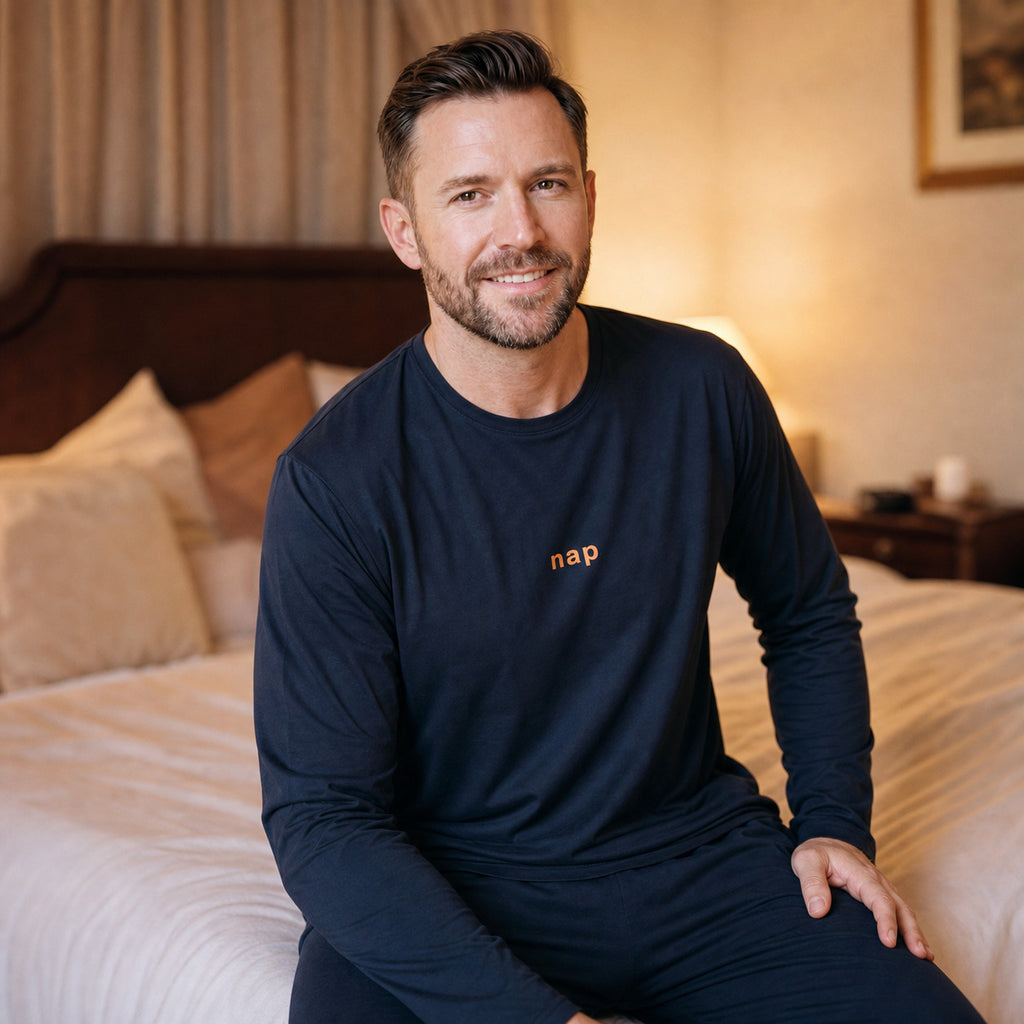 Homme souriant portant le pyjama homme hiver bleu marine dans une chambre boudoir