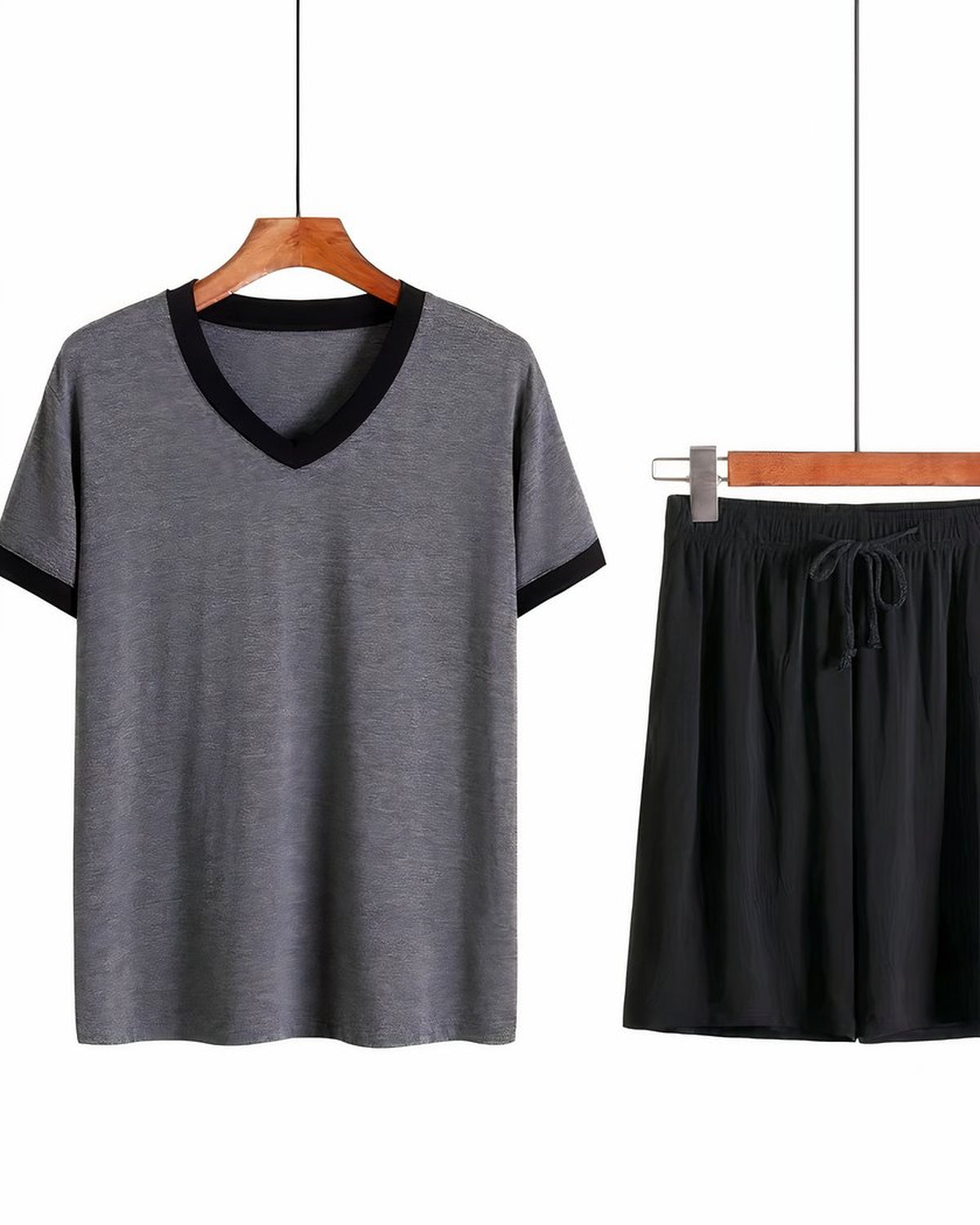 Ensemble de pyjama homme suspendu à un cintre de bois, tee-shirt gris à encolure en V et short noir assorti