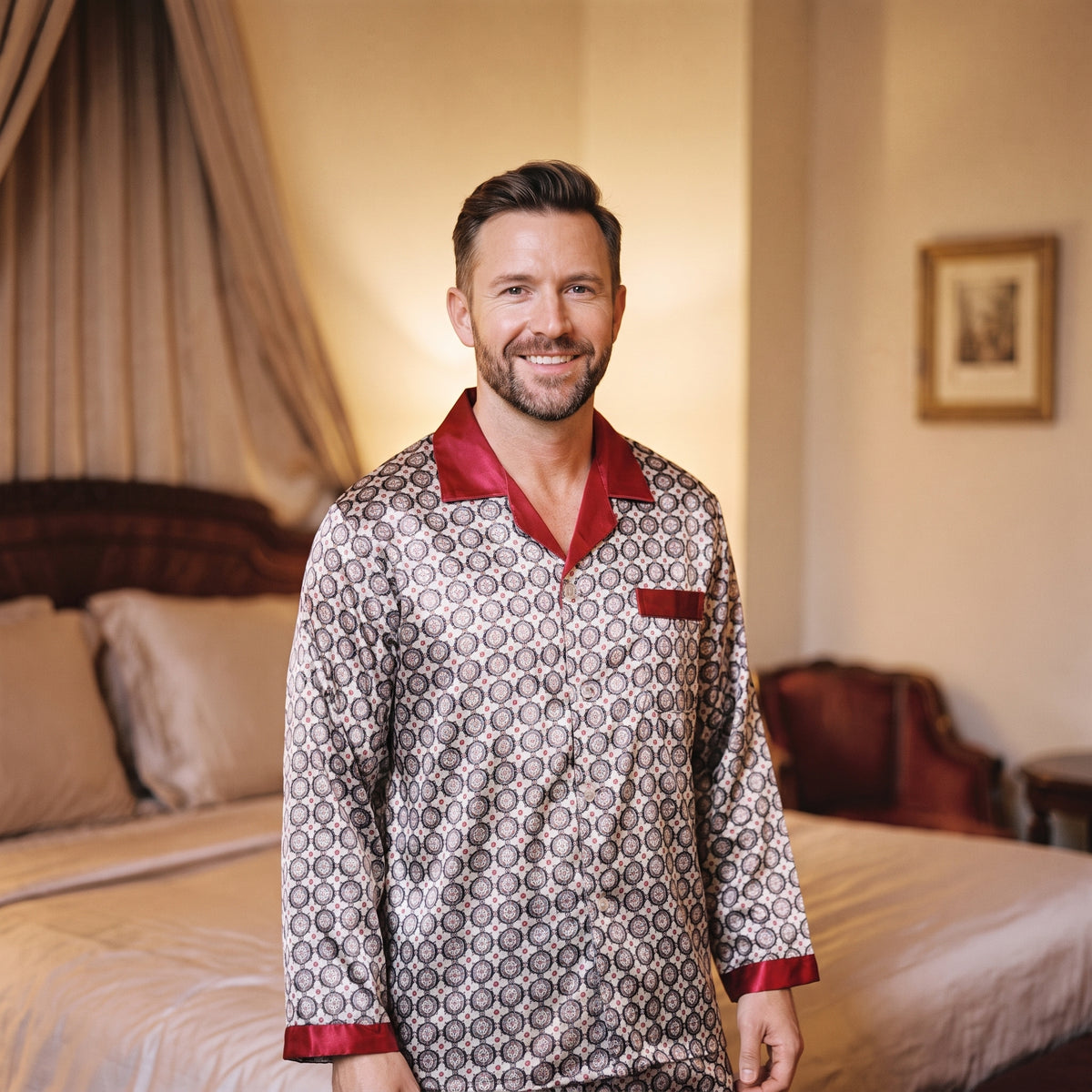 Homme souriant en pyjama à motif circulaire le soir dans une chambre élégante