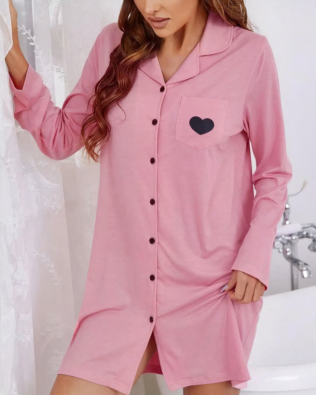Robe de chambre rose boutonnée portée de face, manches longues et coupe droite