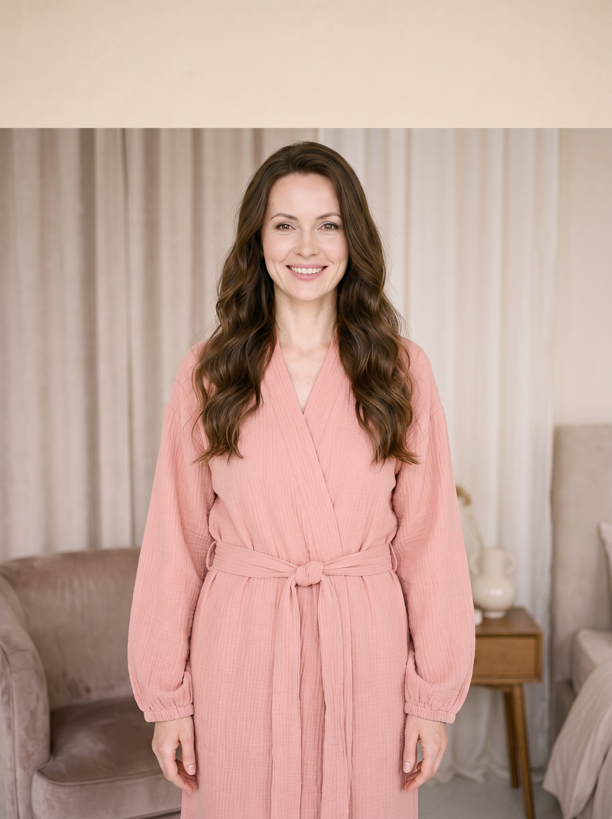 Femme souriante portant une robe de chambre longue rose ceinturée dans un boudoir