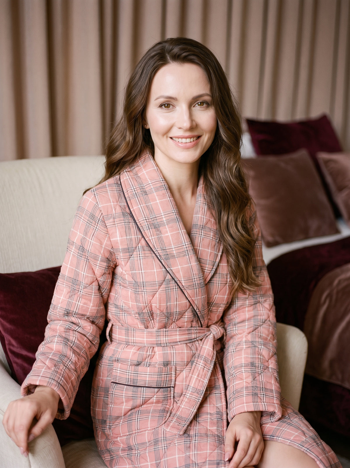 Femme souriante portant la robe de chambre chaude rose à carreaux