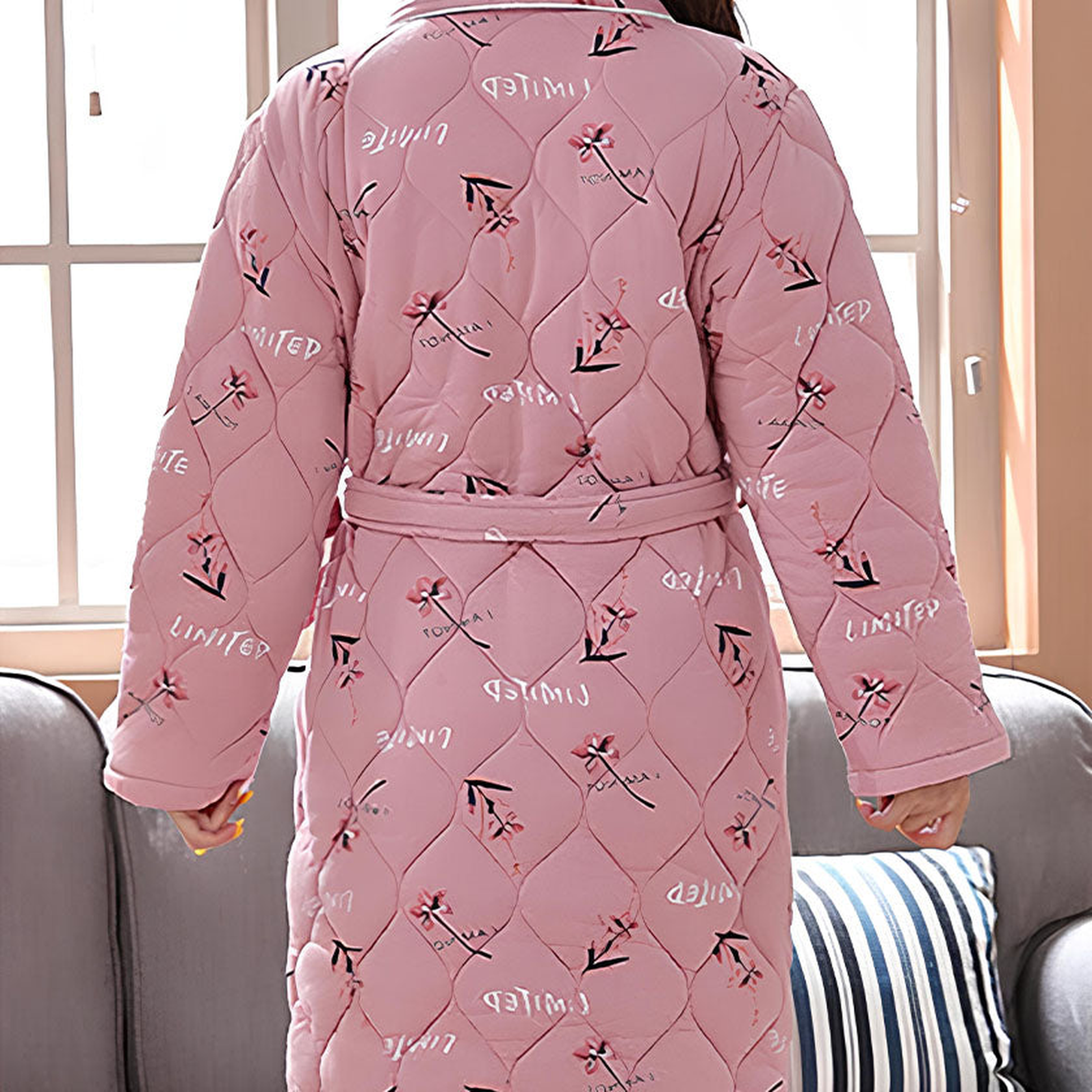 Dos matelassé et ceinture de la robe de chambre rose fleurie Image