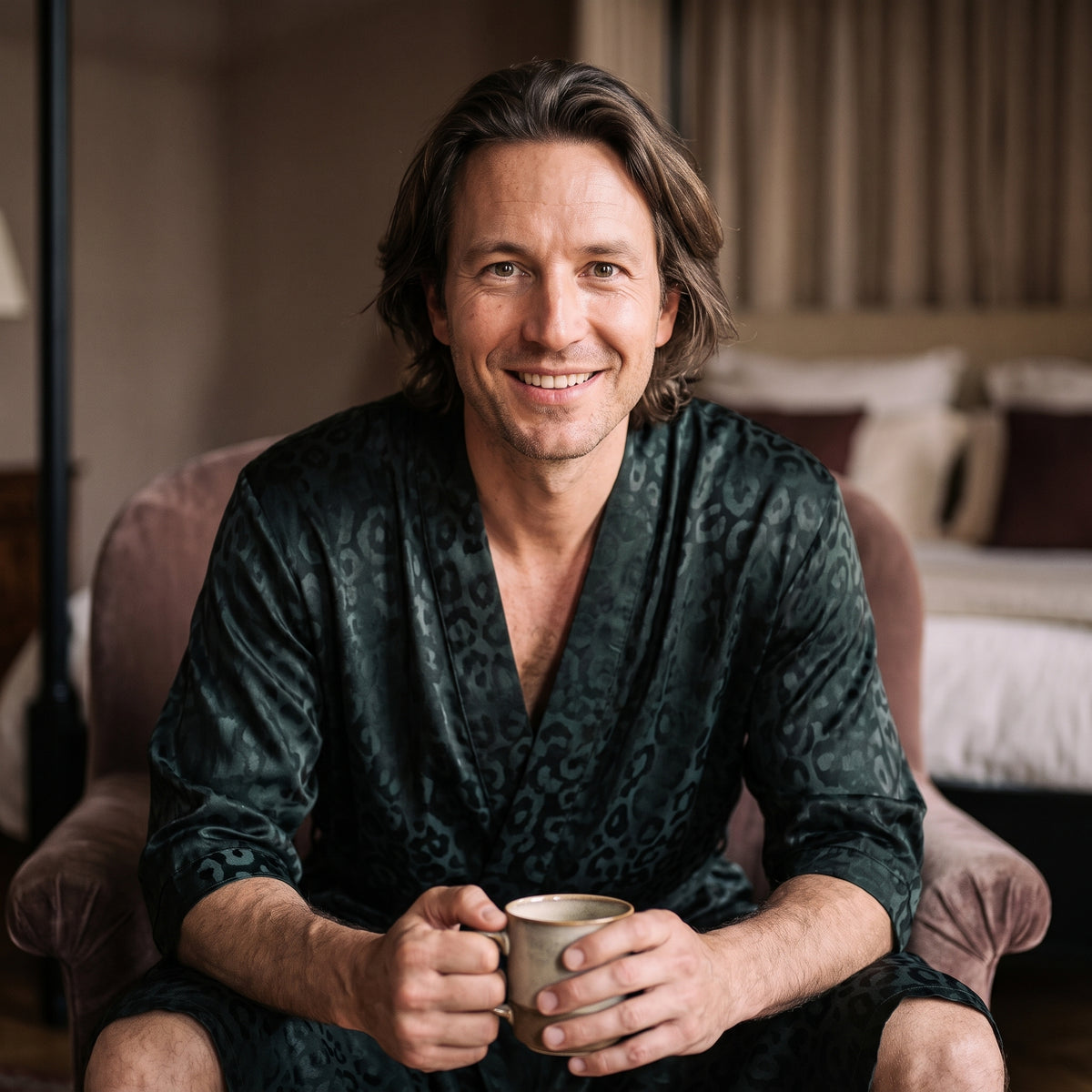 Homme souriant assis avec une tasse en robe de chambre homme vert sombre