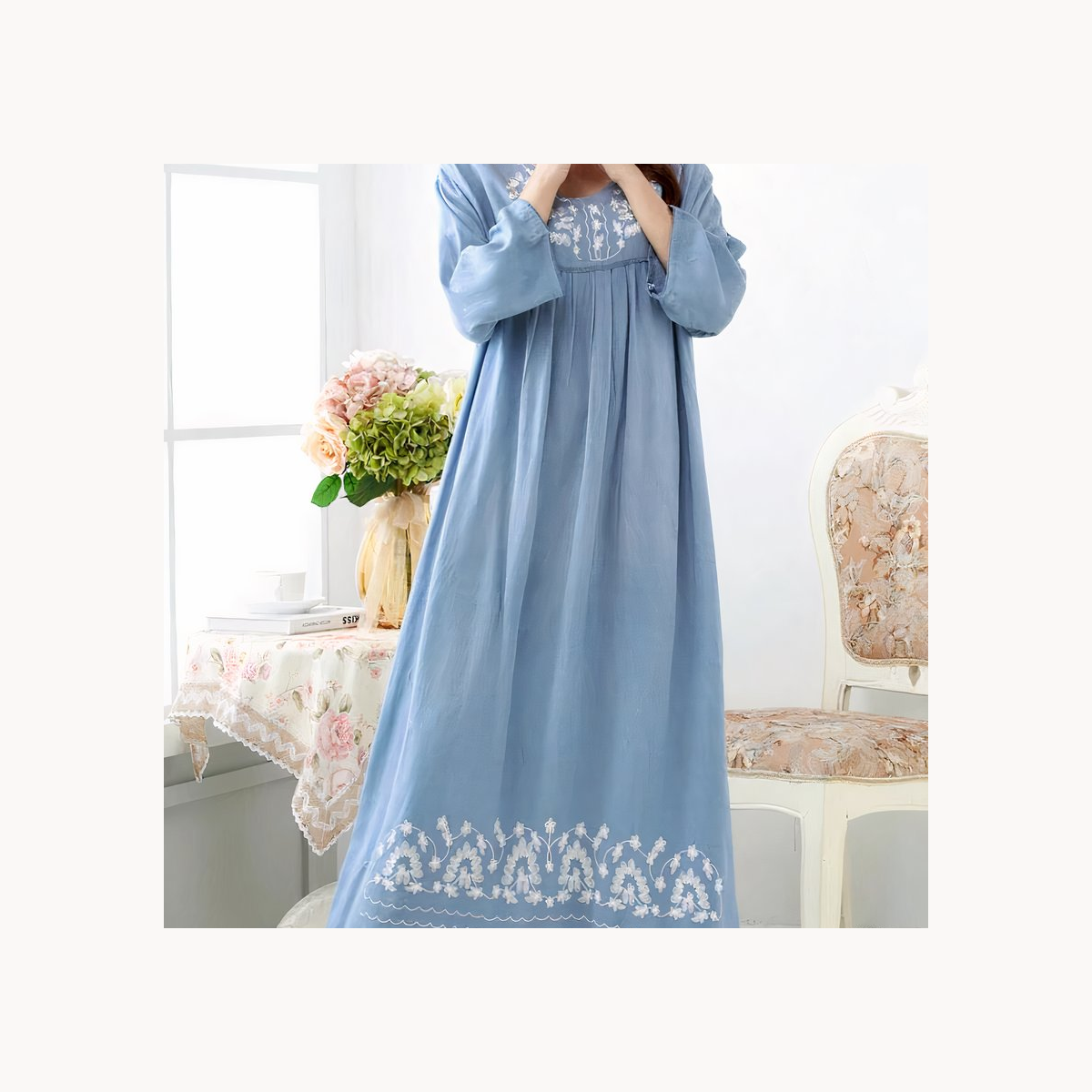 Chemise de nuit longue bleue au réveil près d’une fenêtre claire