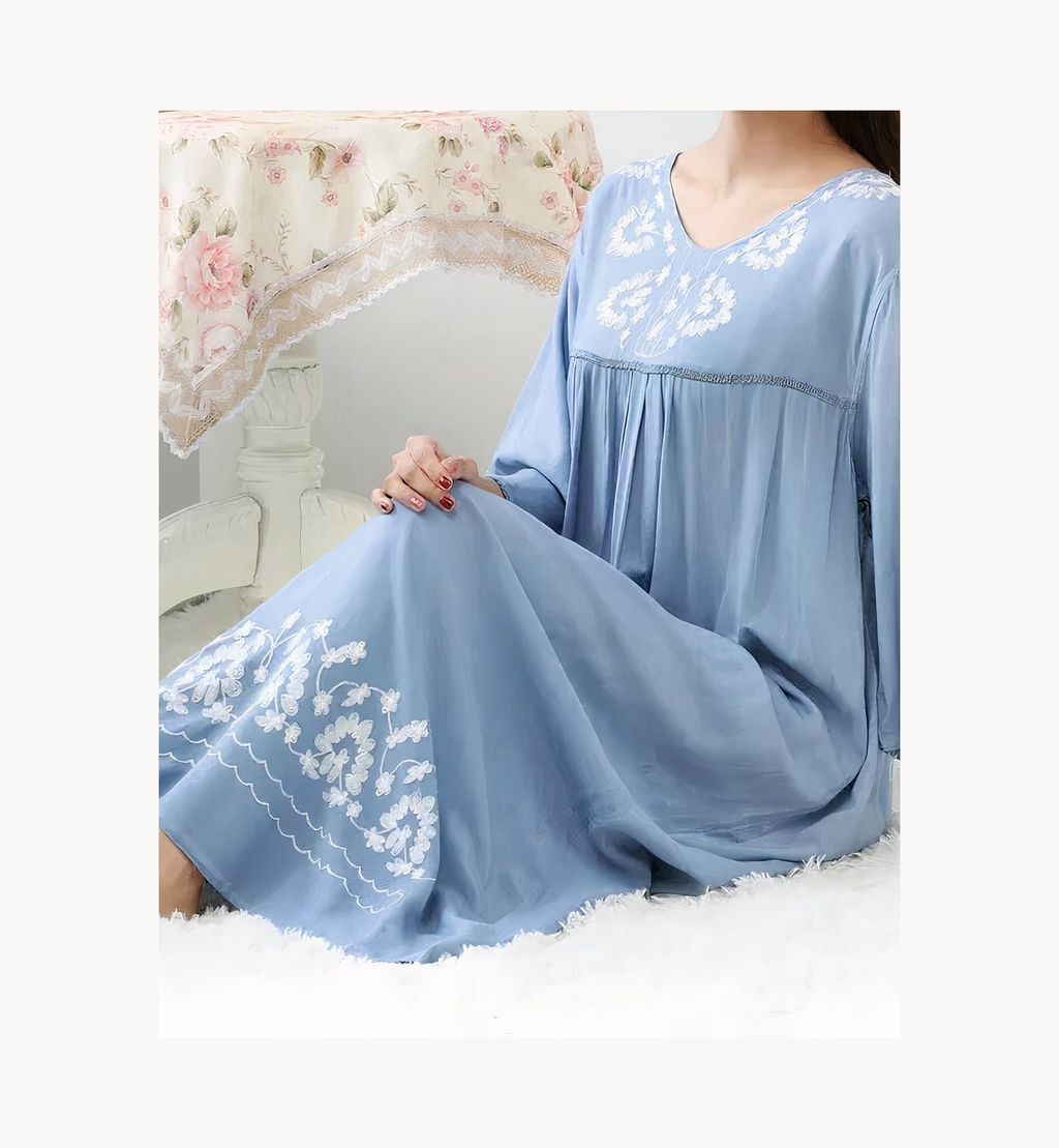 Chemise de nuit longue bleue brodée, portée assise et vue de près
