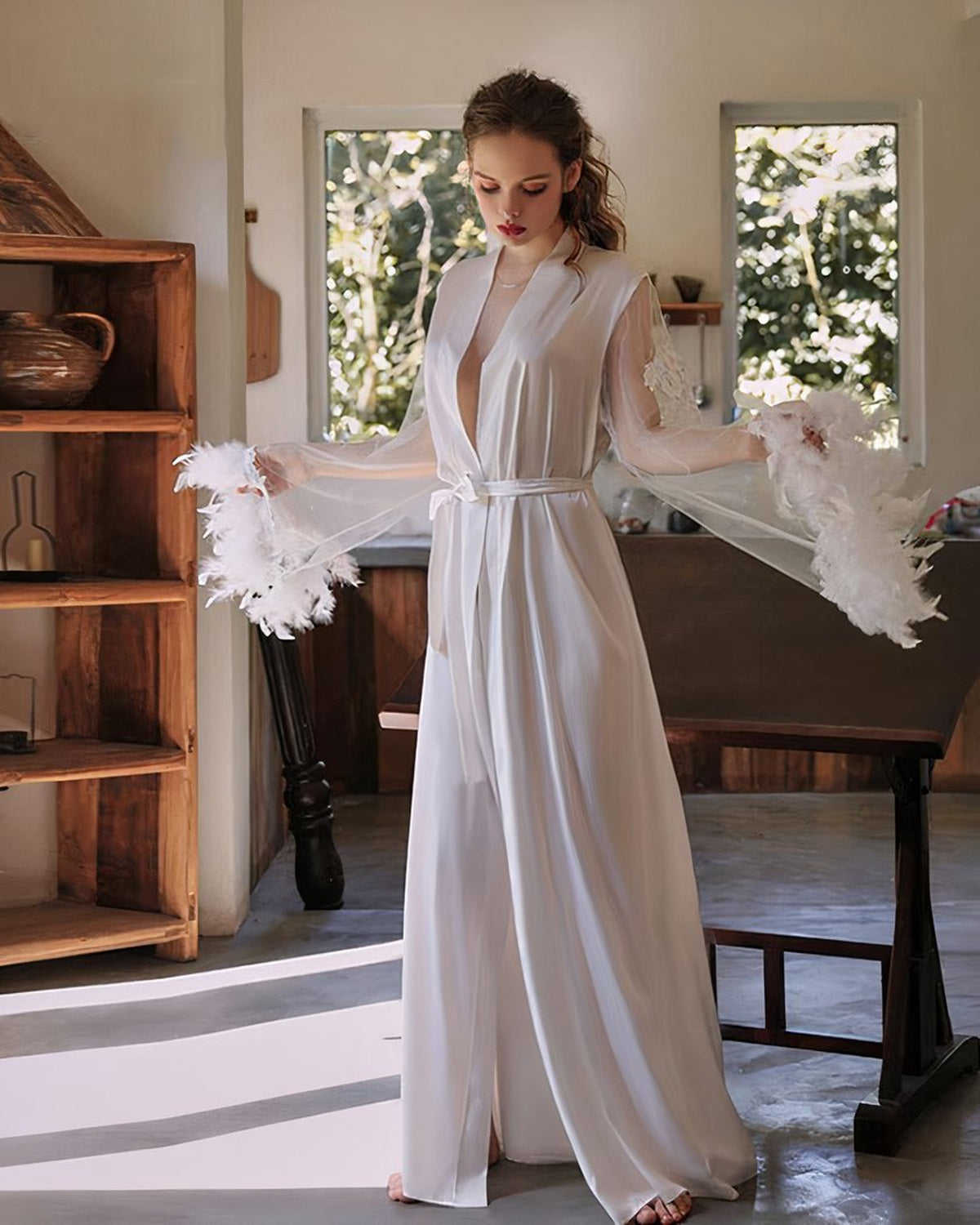 Nuisette en satin blanc ivoire portée debout de face, manches transparentes et plumes