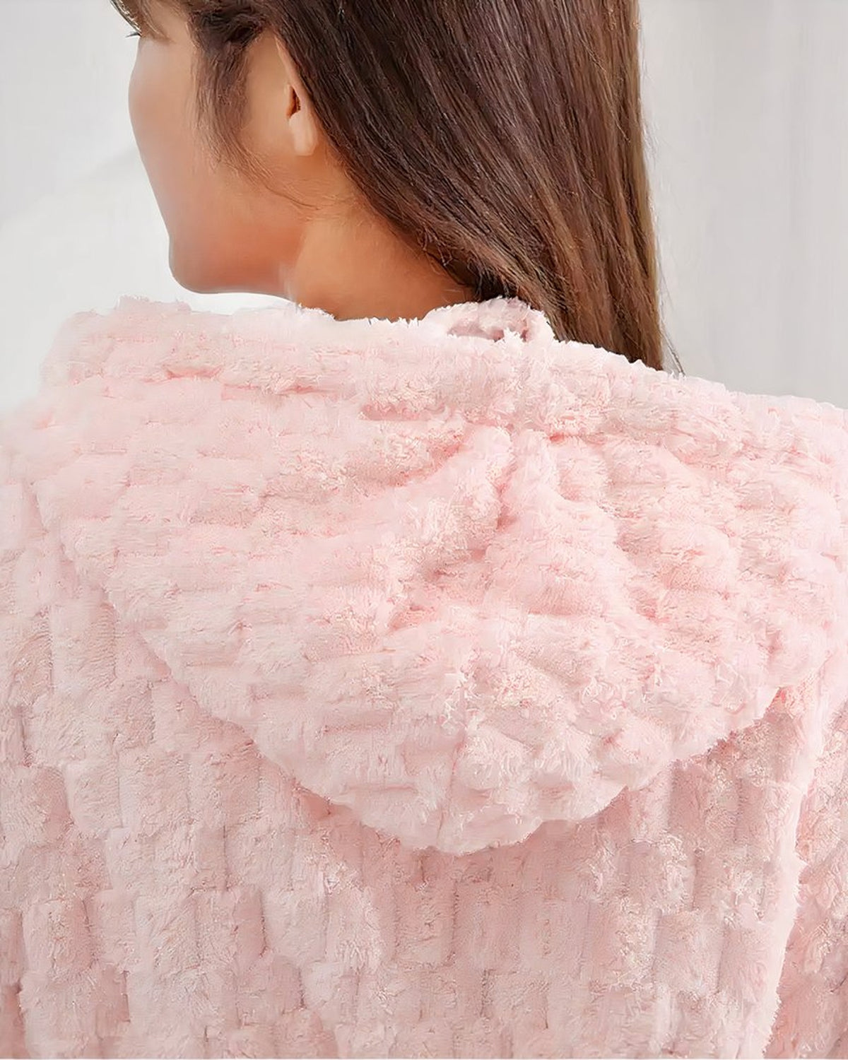 Gros plan sur la capuche et le col chale du peignoir polaire rose, texture gaufree en relief