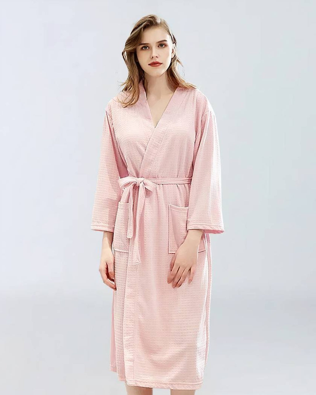 Femme portant un peignoir de bain rose, vue de face
