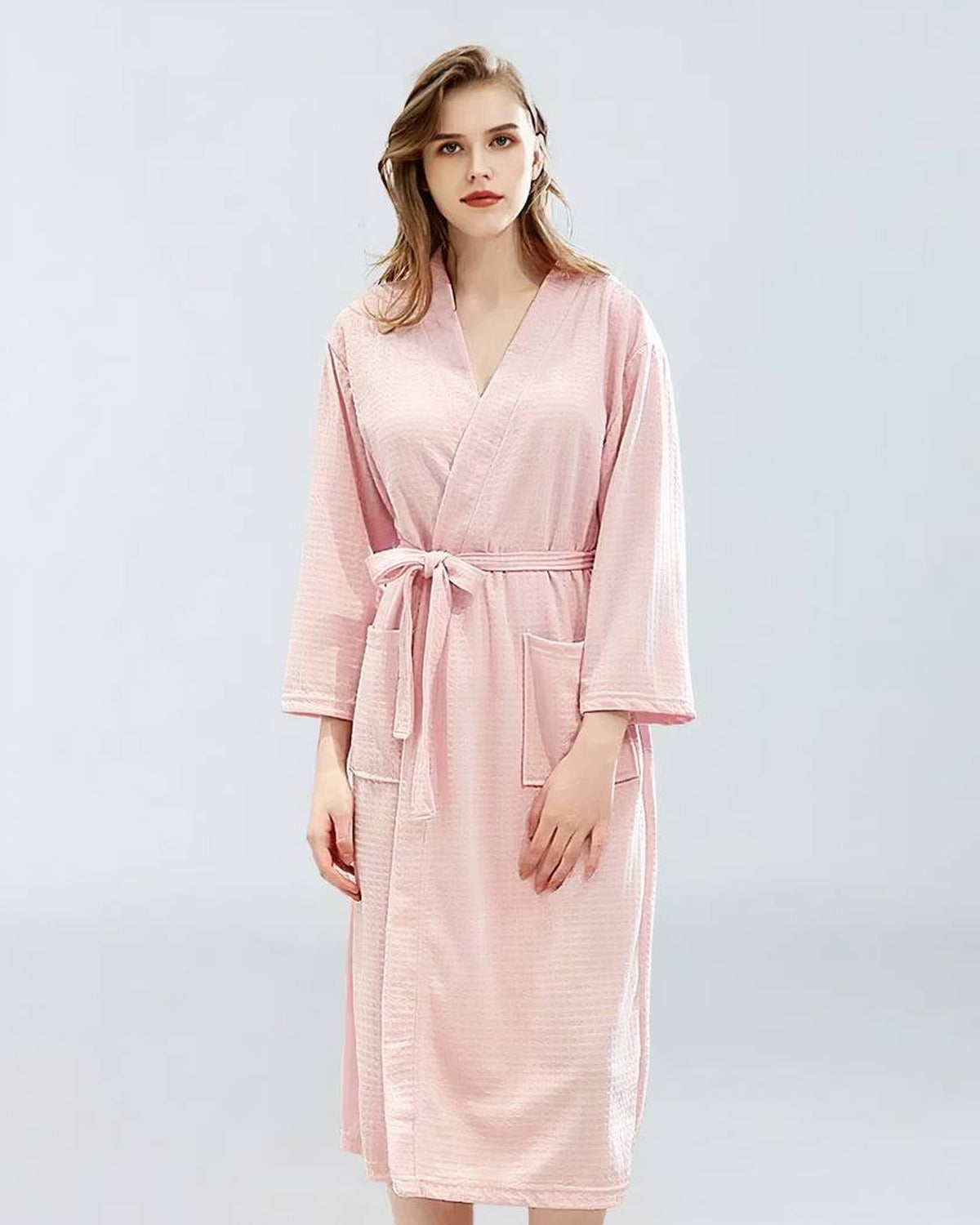 Femme portant un peignoir de bain rose, vue de face