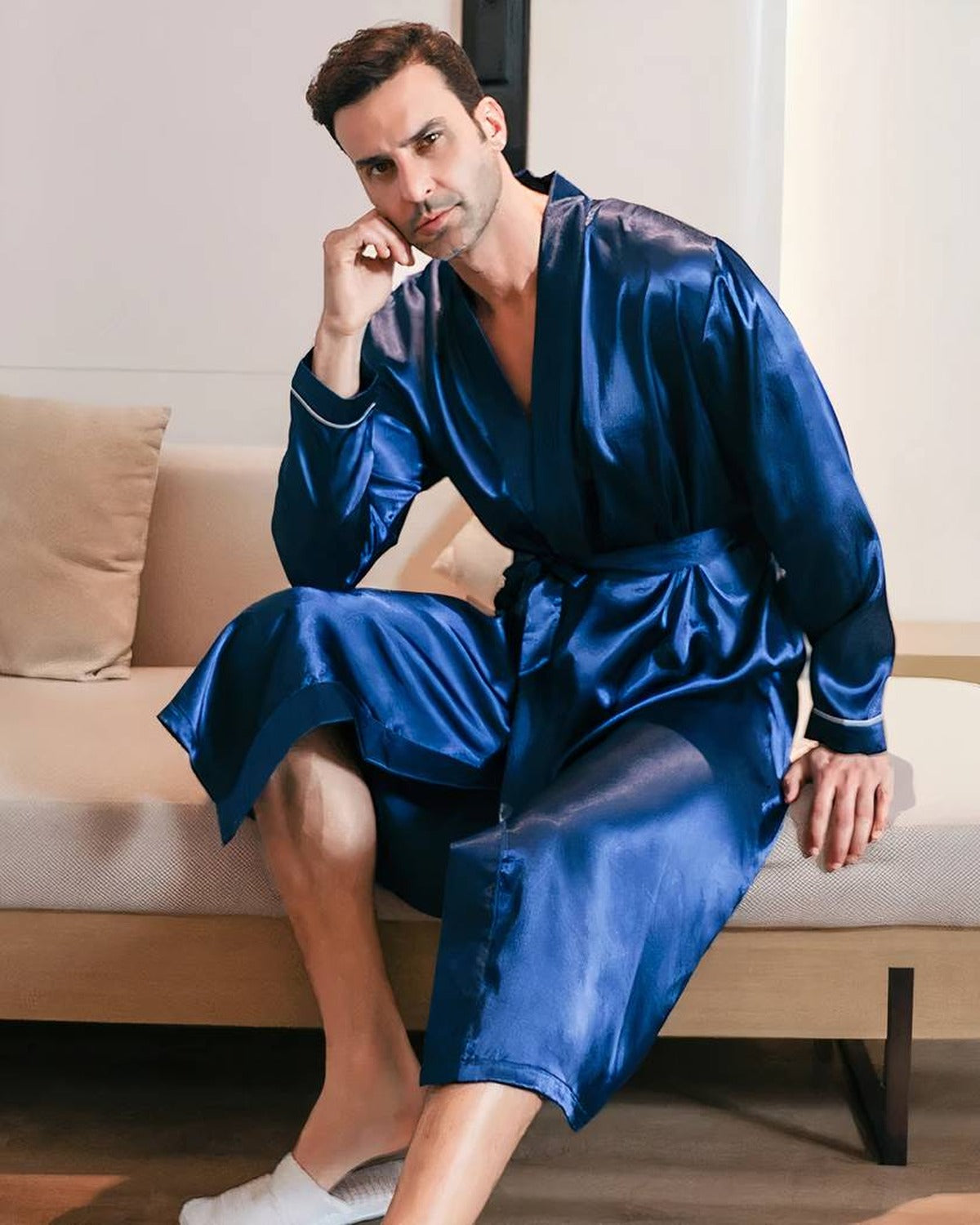 Homme assis portant la robe de chambre satinee noire, posture detendue