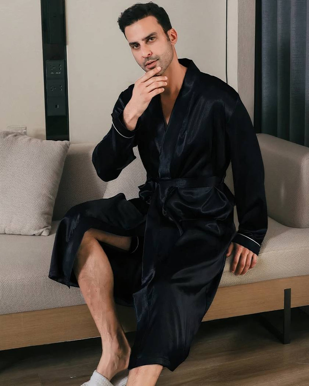 Homme assis de face portant la robe de chambre satinee noire, pose pensive