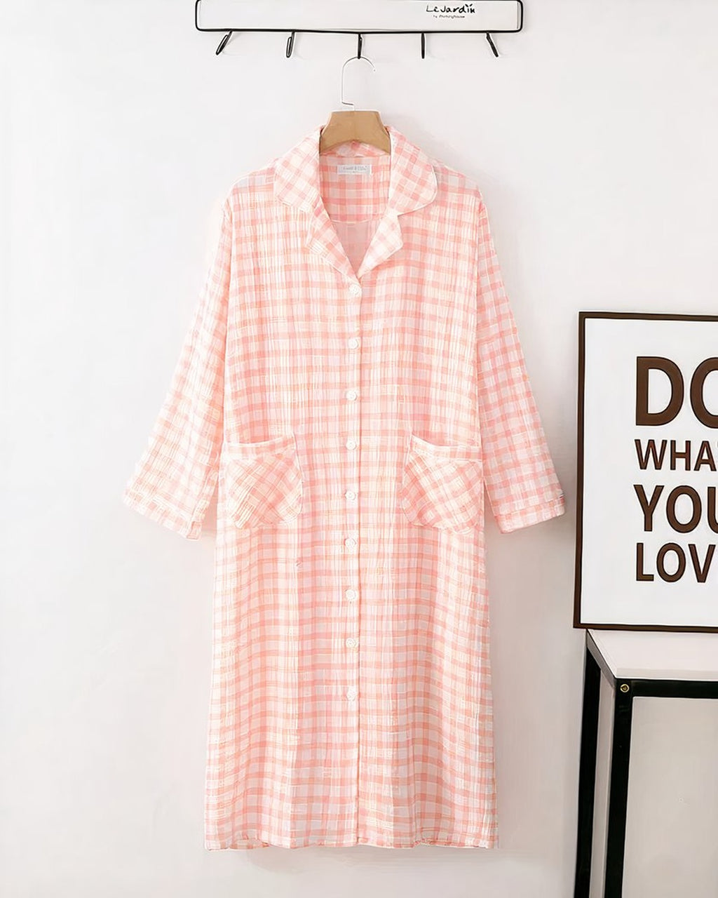 Robe de chambre a carreaux rose blanc suspendue sur cintre
