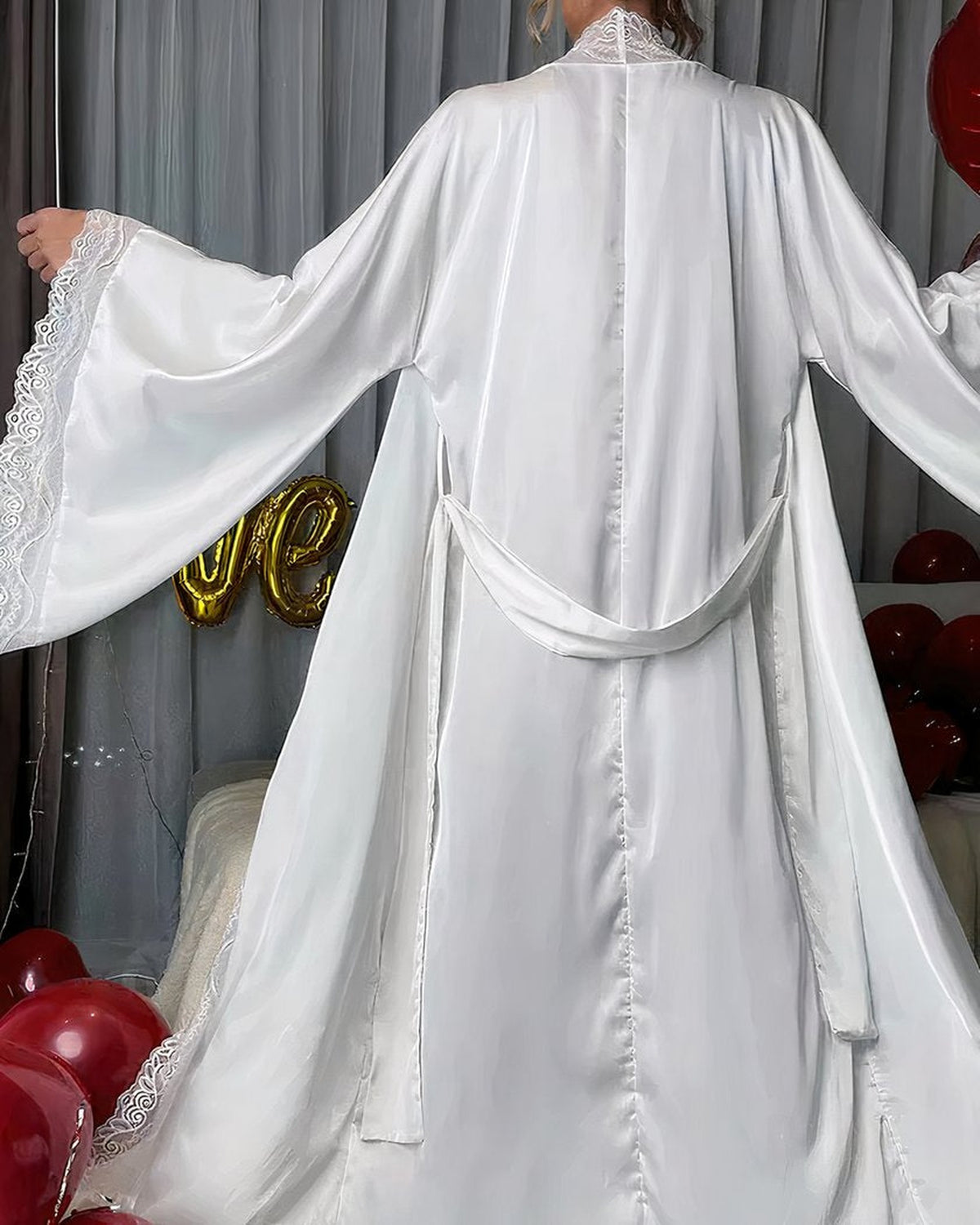 Dos de la robe de chambre blanche en satin, ceinture nouee et dentelle au col