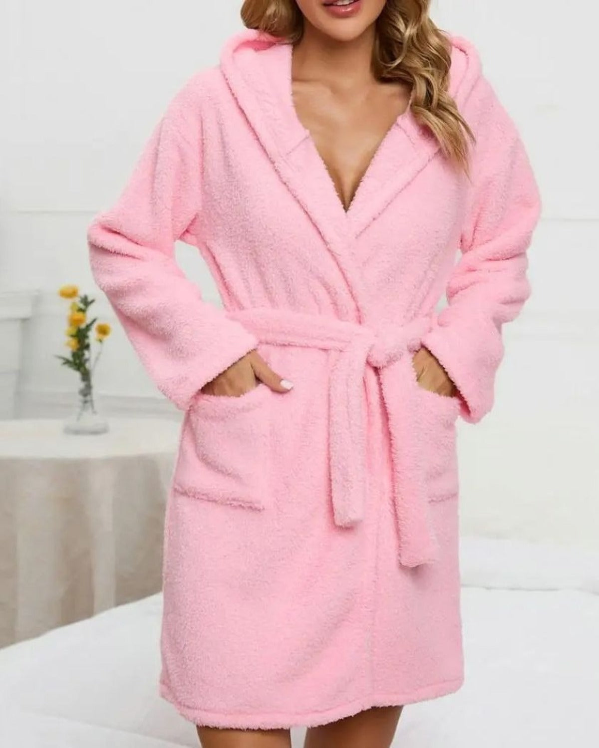 Femme portant le peignoir court rose en peluche a capuche, mains dans les poches