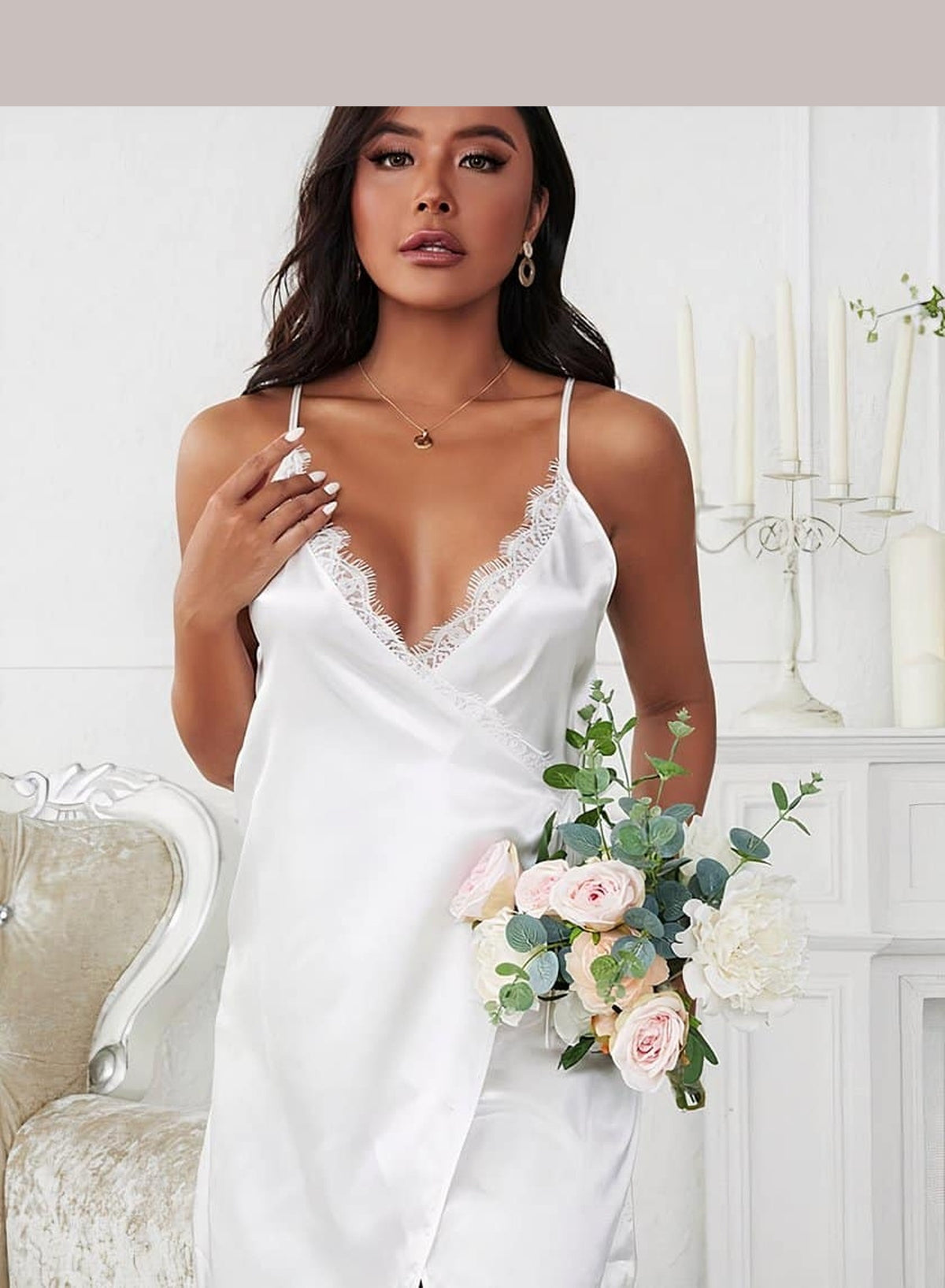 Nuisette blanche en satin portée par un modèle, vue de face avec bouquet de fleurs