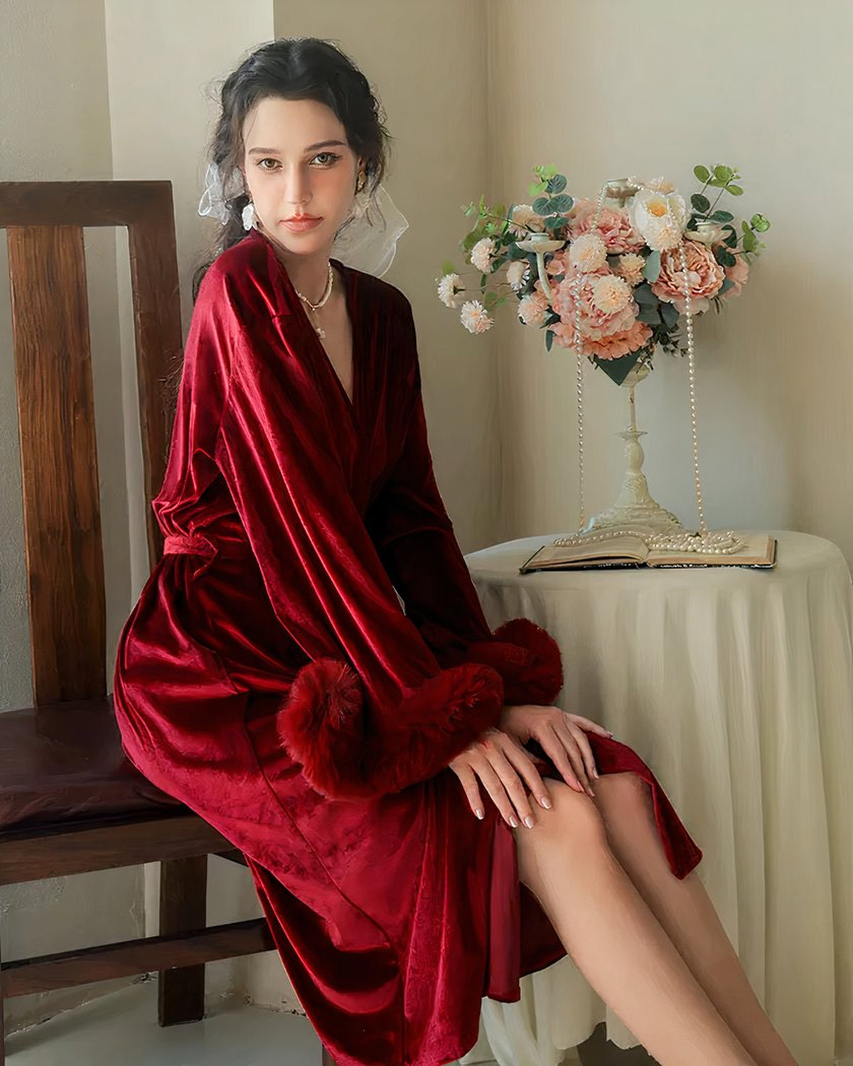 La robe de chambre en velours rouge portée assise, poignets de fourrure