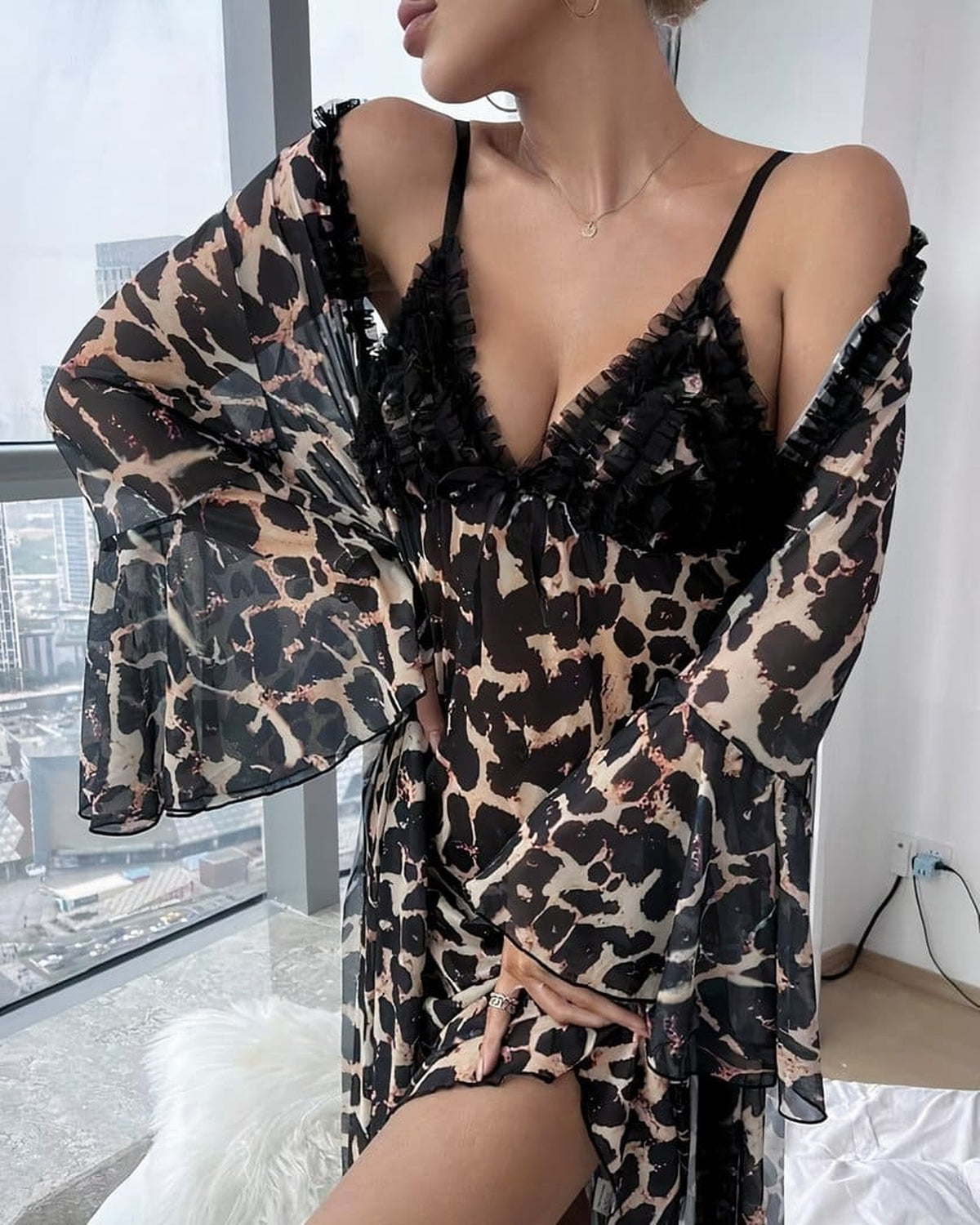 Décolleté de la nuisette léopard à volant noir, portée sous le peignoir assorti