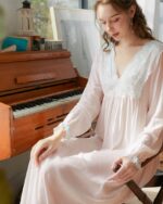 Femme blonde avec une nuisette blanche transparente assise sur une chaise en bois devant un piano