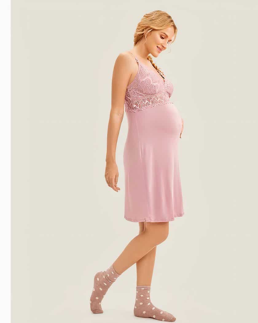 On voit une femme blonde enceinte qui porte une superbe nuisette rose avec un empiècement en dentelle. Elle est très féminine.