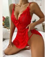 Femme à genoux sur un lit, vêtue d'une nuisette en dentelle rouge avec un col v.