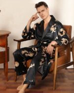 Home brun assis sur un fauteuil marron en nuisette noire en motif dragon couleur or