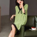 Femme asiatique assise sur un canapé kaki portant une nuisette verte
