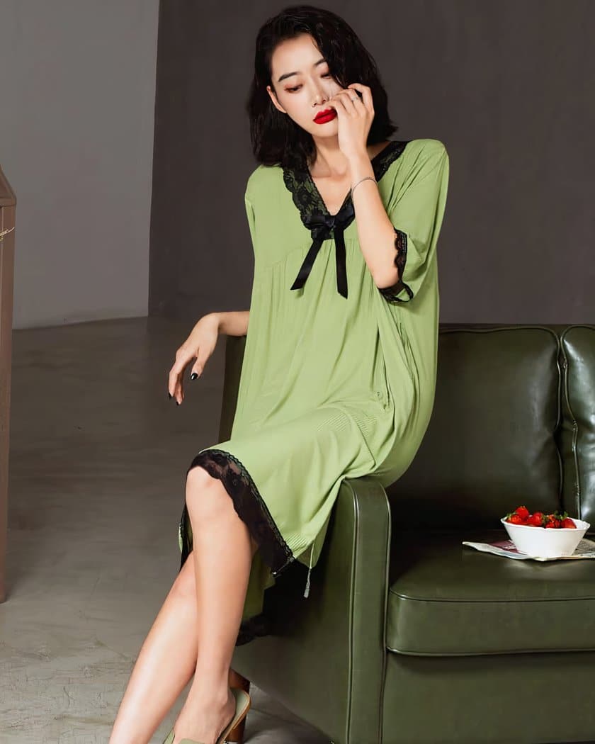 Femme asiatique assise sur un canapé kaki portant une nuisette verte