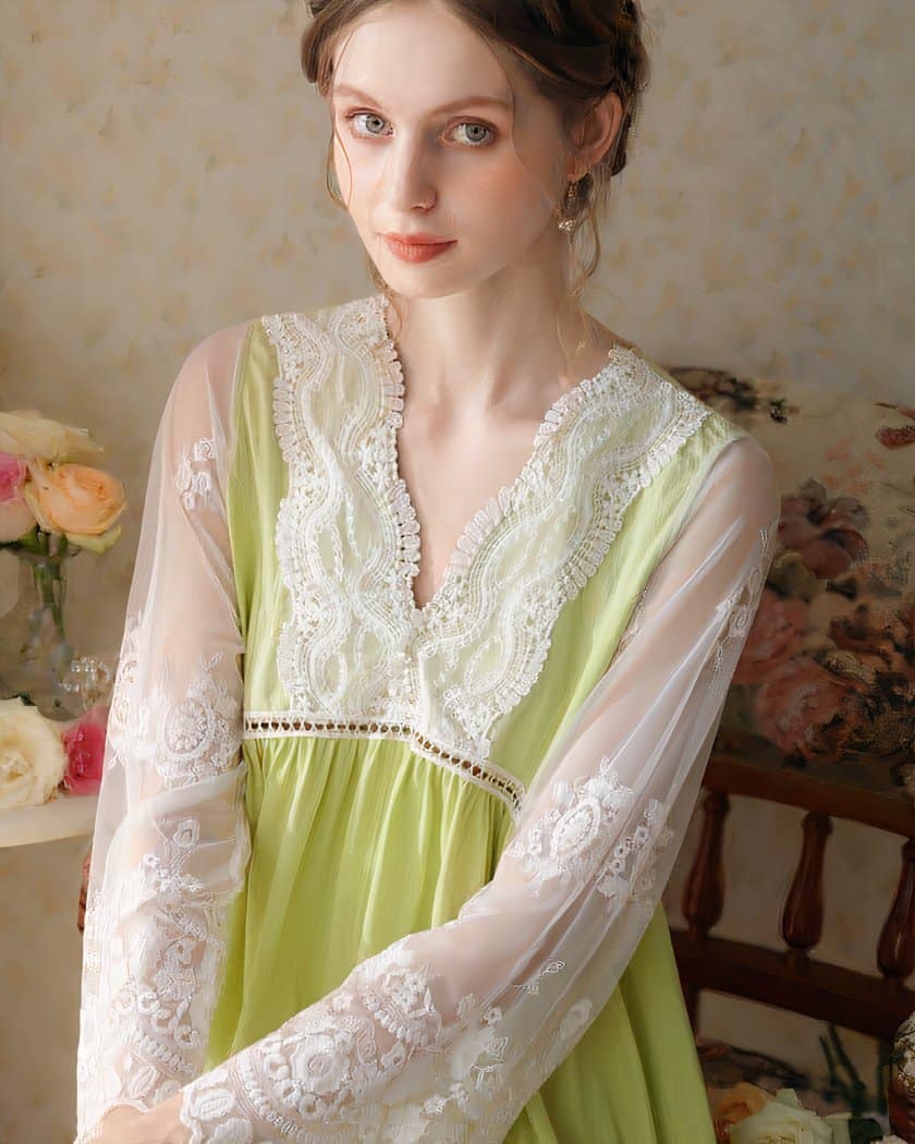 Femme en nuisette verte avec de la dentelle blanche. Derrière se trouve des fleurs et des coussins