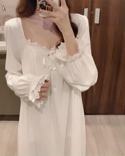 Photo d'une femme portant une nuisette longue en dentelle devant son miroir