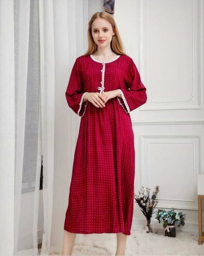 Photo d'une femme portant une nuisette longue rouge à coté de rideaux