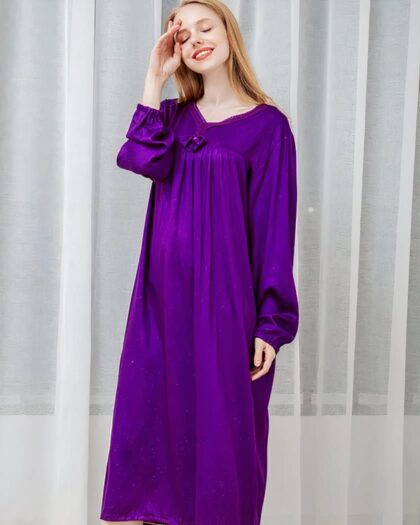 Photo d'une femme portant une nuisette longue de couleur violette devant un rideau semi-transparent