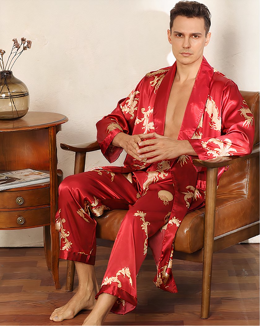Nuisette homme de couleur rouge avec imprimé de dragons dorés, portée par un homme assis sur une chaise en bois