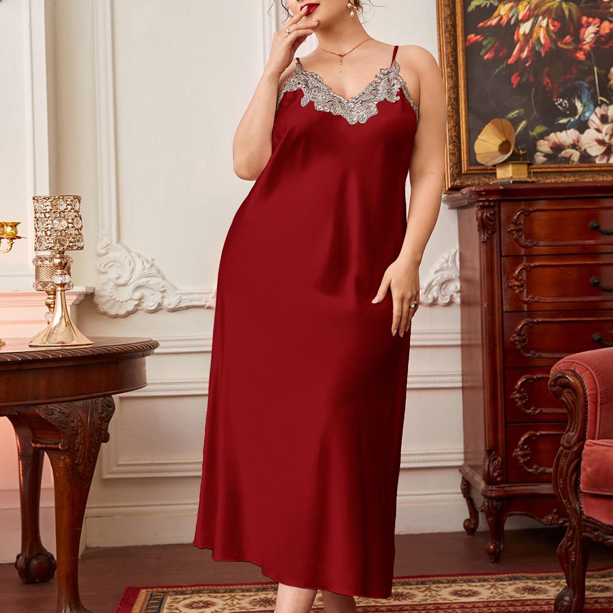 Nuisette grande taille de couleur rouge avec de la dentelle, portée par une femme debout dans une pièce luxueuse