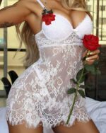 Femme à genoux sur un lit portant une nuisette en dentelle blanche avec une rose à la main