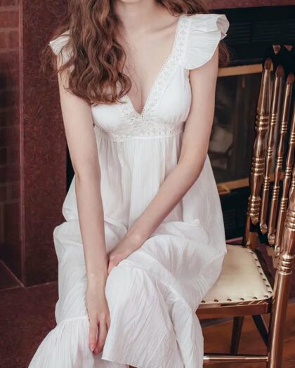 Nuisette Mi-longue Blanche en Polyester avec Col en V sur une femme assise sur fond marron