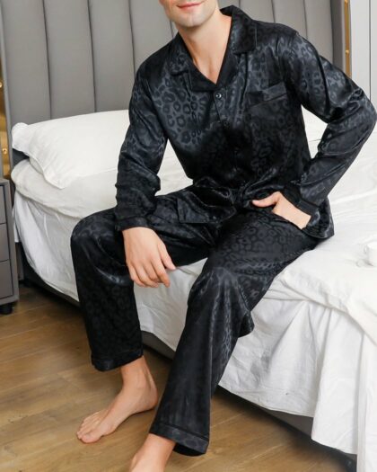 Pyjama Homme Été à Deux Pièces avec imprimés Léopard Noirs, orté par un homme assis sur un lit