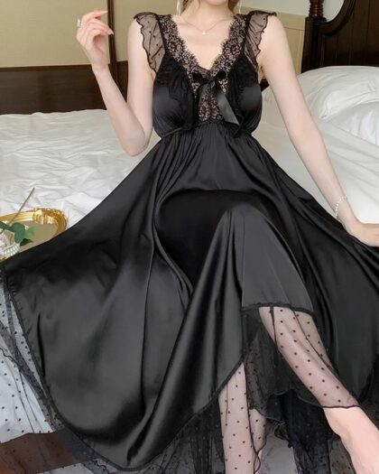 Chemise de Nuit Romantique à Bretelles avec Dentelle, de couleur noire, porté par une femme assise sur un lit.