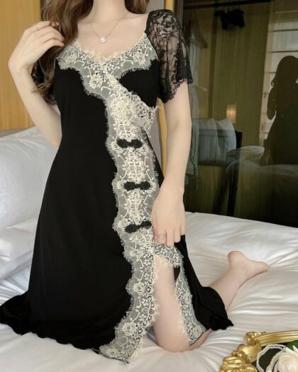 Chemise de Nuit Romantique à Manches Courtes en Dentelle, de couleur noire avec dentelle blanche, porté par une femme sur un lit.
