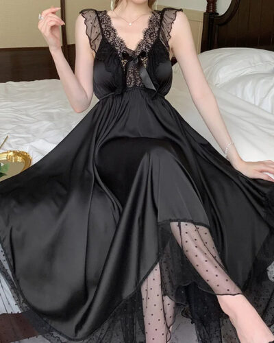 Chemise de Nuit Romantique à Bretelles avec Dentelle, de couleur noire, porté par une femme assise sur un lit.