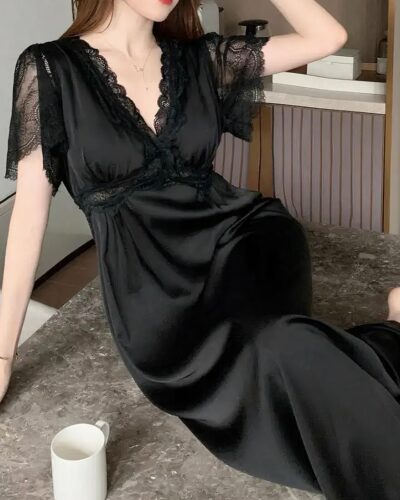 Chemise de Nuit Romantique satinée à Manches courtes, de couleur noire, porté par une femme.